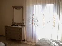 Vista d'insieme della camera Amélie con poltroncina blu e dipinti botanici di rose