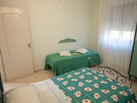 Angolo della camera Chloé con comodino petrolio e armadio verde decorato